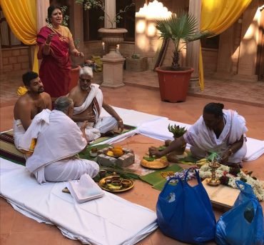 Pandit performing sacred fire ritual during Hindu wedding ceremony with family participation
